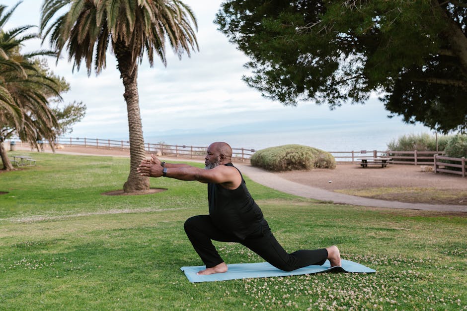 A person peacefully stretching on a yoga mat near green plants